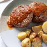 Hambúrguer ao molho BBQ com batatas assadas, comida natural e saudável.