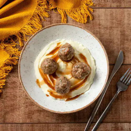Almôndegas de carne com purê de batatas e molho saboroso.
