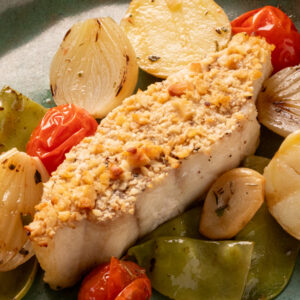 Filé de pescada com crosta de castanha e legumes